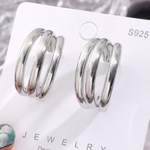 Silver three-layered c-shaped earrings.